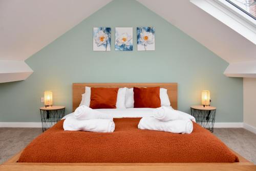 una camera da letto con un grande letto con due comodini di Village Life, cosy yet spacious home a Oswestry