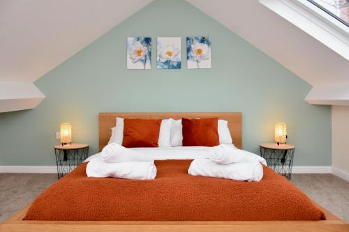 Village Life, cosy yet spacious home في أوسويستري: غرفة نوم بسرير كبير مع مواقف ليلتين