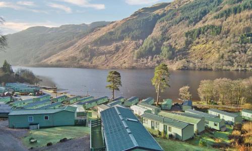 a group of houses next to a body of water at Loch Eck Holiday Park in Coirantee