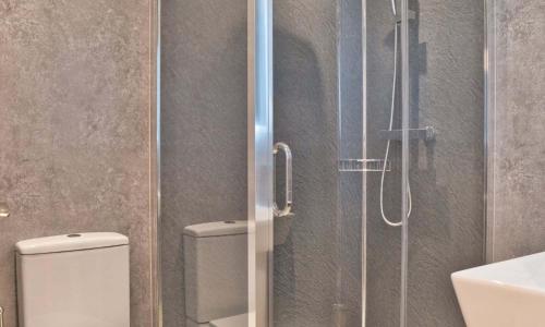 a bathroom with a toilet and a glass shower at Loch Eck Holiday Park in Coirantee