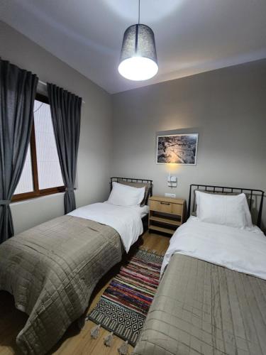 two beds sitting next to each other in a bedroom at Dhami Apartment in Gjirokastër