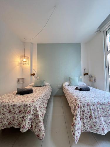 two beds sitting next to each other in a room at Apartamento San Juan 1 in Murcia
