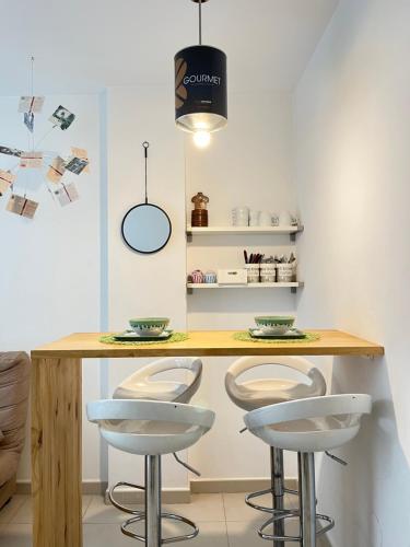 a kitchen with a table and two stools at Apartamento San Juan 1 in Murcia