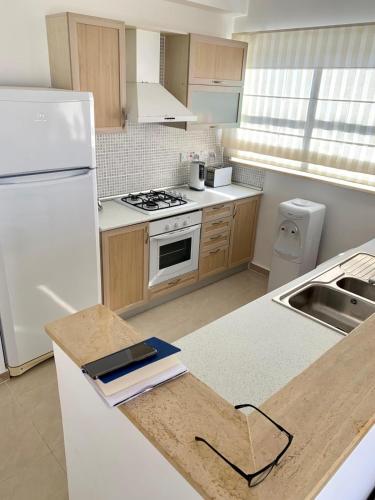 a kitchen with a white refrigerator and a sink at Boho Bay Apartment in Akanthou