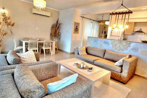 a living room with two couches and a table at Boho Bay Apartment in Akanthou