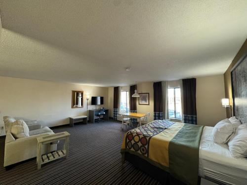 a hotel room with a bed and a couch at Super 8 by Wyndham Columbia Clark Lane in Columbia