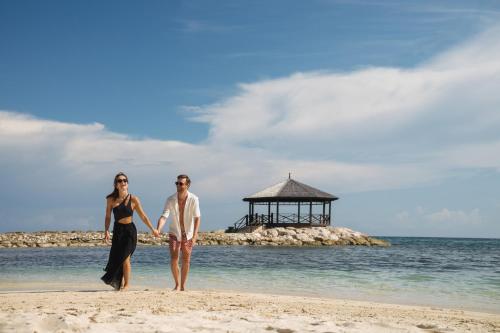 a man and a woman standing on the beach at Jewel Grande Montego Bay Resort and Spa in Montego Bay