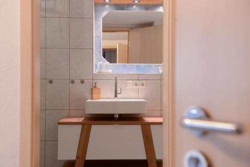 a bathroom with a sink and a mirror at Ferienwohnung Malou in Tettnang