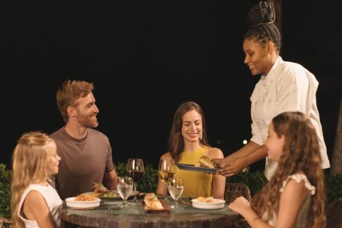 a group of people standing around a table with a man holding a plate of food at Jewel Grande Montego Bay Resort and Spa in Montego Bay
