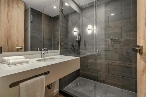 ein Bad mit einem Waschbecken und einer Dusche in der Unterkunft Hotel Distrito ZF in Bogotá
