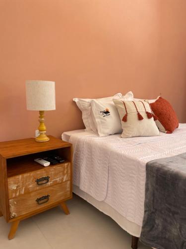a bed with pillows and a table with a lamp at Pouso da Rita - Tiradentes in Tiradentes