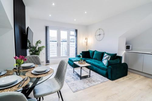 a living room with a green couch and a table at Modern 1-Bed Apartment in Buckinghamshire with Free WiFi, Parking & Garden in Buckinghamshire