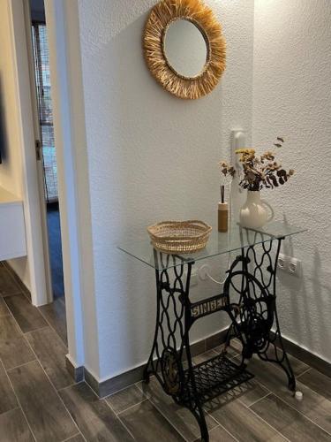 a glass table with a mirror on the wall at Brisamar, serenidad frente al mar in Bajamar
