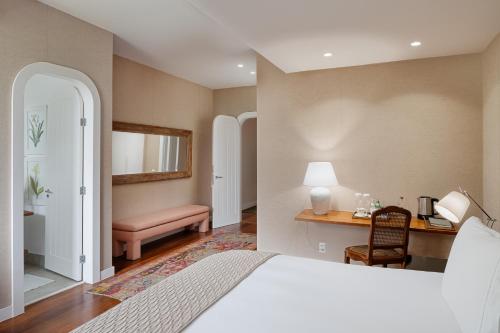a bedroom with a bed and a desk and a chair at Vila Santa Teresa in Rio de Janeiro