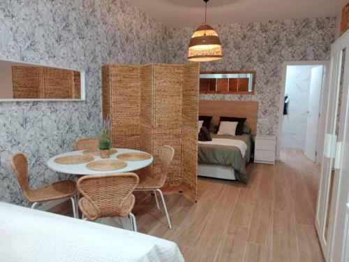 1 dormitorio con 1 cama, mesa y sillas en estudio el Torcal, en Málaga