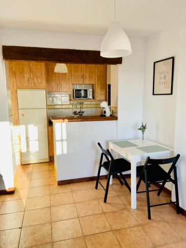 a kitchen with a table and two chairs and a white table at Apartamento con vistas al mar in Conil de la Frontera