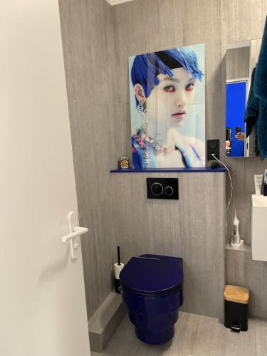 ein Badezimmer mit einem blauen WC mit einem Bild an der Wand in der Unterkunft Le Loft du Homard Bleu à Saint-Malo Intra-Muros in Saint-Malo
