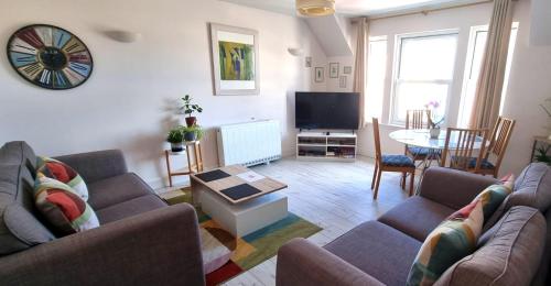 a living room with two couches and a tv at Heart of Inverness-city apartment in Inverness
