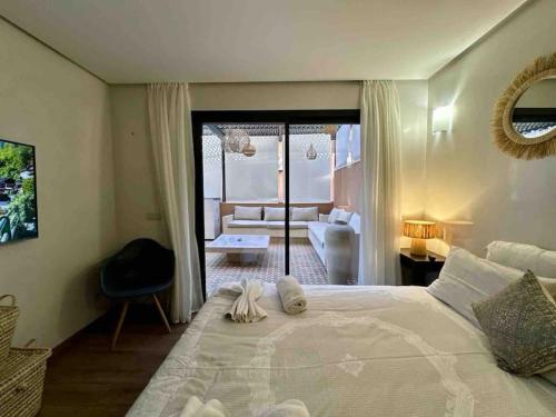 a bedroom with a large bed and a living room at Appart de standing + piscine sur le toit in Marrakech