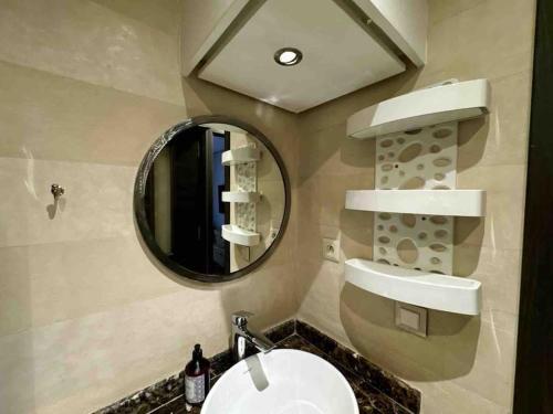 a bathroom with a sink and a mirror at Appart de standing + piscine sur le toit in Marrakech