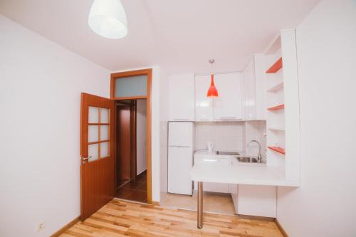 een keuken met witte kasten en een wastafel bij Apartment DV Magnolia in Tivat