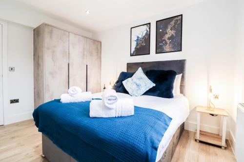 BuckinghamshireにあるModern 1-Bed Apartment in Buckinghamshire with Free WiFi, Parking & Gardenのタオルが敷かれた大きなベッドのある寝室