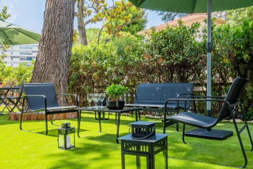un groupe de chaises et de tables sous un parapluie dans l'établissement Garden-level apartment 10-min on foot to City Center, à Cannes
