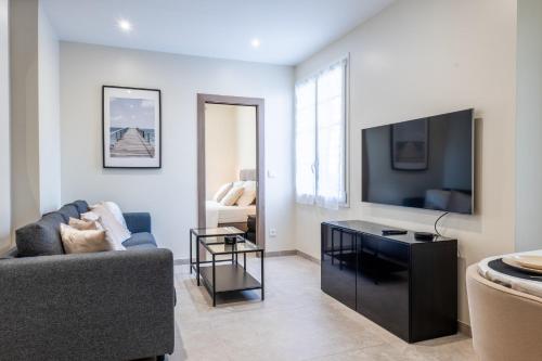 un salon avec un canapé et une télévision à écran plat dans l'établissement Garden-level apartment 10-min on foot to City Center, à Cannes