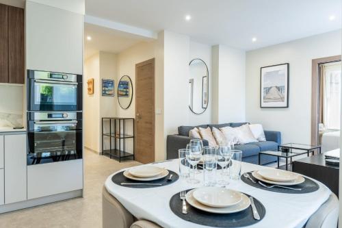 une cuisine et un salon avec une table et un canapé dans l'établissement Garden-level apartment 10-min on foot to City Center, à Cannes