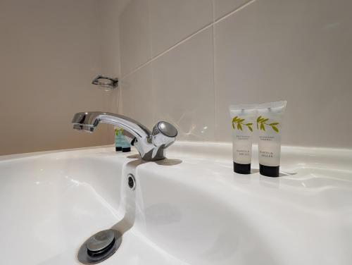 a bathroom sink with a faucet and a toothbrush at Bay & Harbour Holiday Apartments & rooms only in Weston-super-Mare