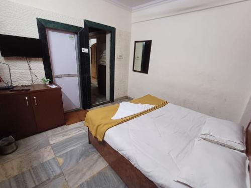 ムンバイにあるSai residencyのベッドルーム(大型ベッド1台、鏡付)