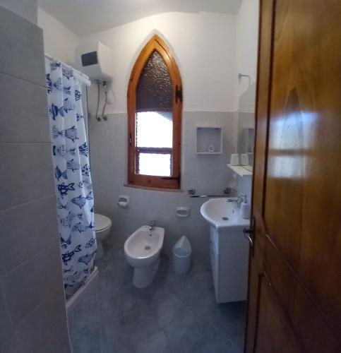 a bathroom with a sink and a toilet and a window at La Calla Bianca in Torre Dei Corsari