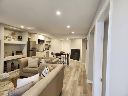 a living room with two couches and a kitchen at Stylish Retreat in North Oshawa in Oshawa