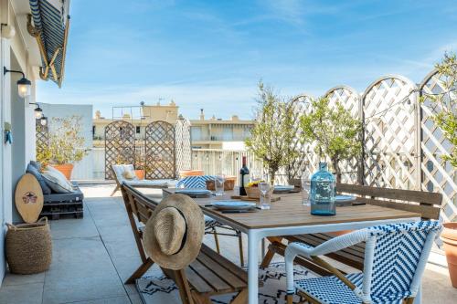 un patio avec une table et des chaises sur un balcon dans l'établissement 2-Br Rooftop in Palm Beach 2-min walk to beaches, à Cannes