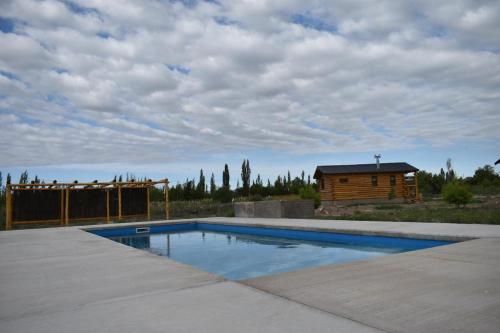 una piscina en un patio con una cabaña en Finca La Vilina en San Rafael