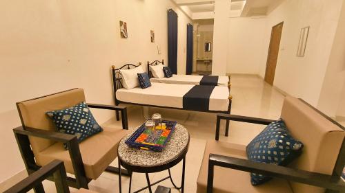 um quarto com duas camas, uma mesa e uma cadeira em Hotel Amazing Udaipur (Prime inn ) em Udaipur