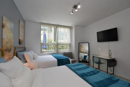 um quarto com 2 camas e uma televisão de ecrã plano em Lovely Midblock building 1 bedroom 1 bathroom apartment em Miami