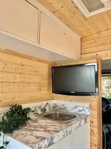 Il comprend une cuisine avec un évier et une télévision à écran plat. dans l'établissement Van Camper Ibiza MB100 Van Voyage, à Sant Carles de Peralta