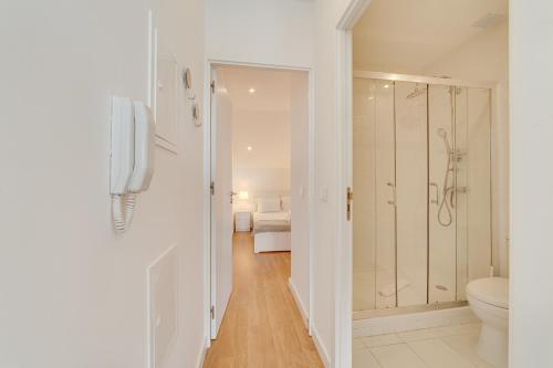 a white bathroom with a toilet and a shower at By the Palace - Ajuda Apartments in Lisbon