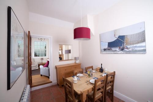 a dining room with a table and chairs and a room at Fort Victoria Cottages - Sea View Cottage in Yarmouth