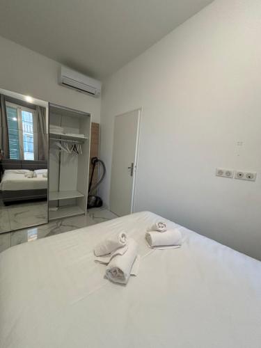 a white room with a bed with towels on it at Appartement 4 couchages Idéalement placé promenade des anglais / Cours Saleya in Nice