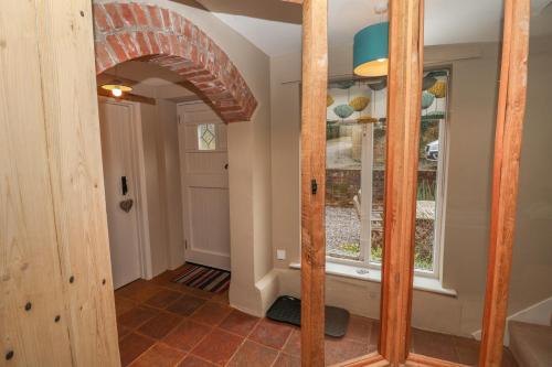 a hallway with an archway and a mirror at 1 The Old Coach House in Laxfield