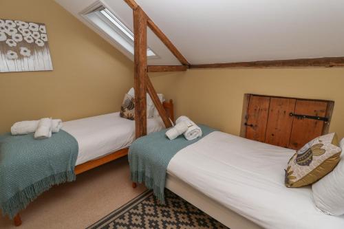 two twin beds in a room with at 1 The Old Coach House in Laxfield