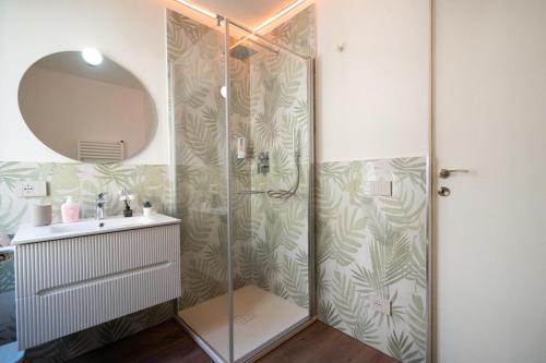 bagno con doccia, lavandino e specchio di Casa Cabernet Lucca a Lucca