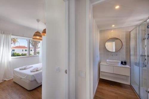 a white bathroom with a sink and a mirror at Sun Lovers Altura T1 Pool & Balcony in Altura
