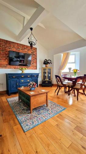 a living room with a table and a dining room at The Three Musketeers, Aramis in Eastbourne