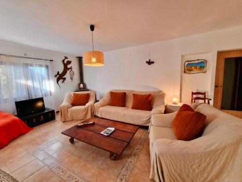 a living room with two couches and a coffee table at Casa Migjorn, immersa nella natura a pochi passi dal mare in Es Calo