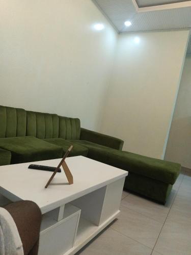 a living room with a green couch and a coffee table at VENUS Villa BOUTIQUE HOTEL KIGALI in Kigali