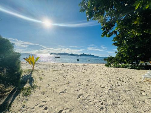 a sandy beach with a bench and the ocean at Digwa Beach Chalet in La Digue