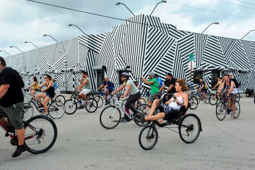 un groupe de personnes faisant du vélo devant un bâtiment dans l'établissement FLiXBEDS - The Latinx MIA Airport- Downtown - Casino - Wynwood, à Miami